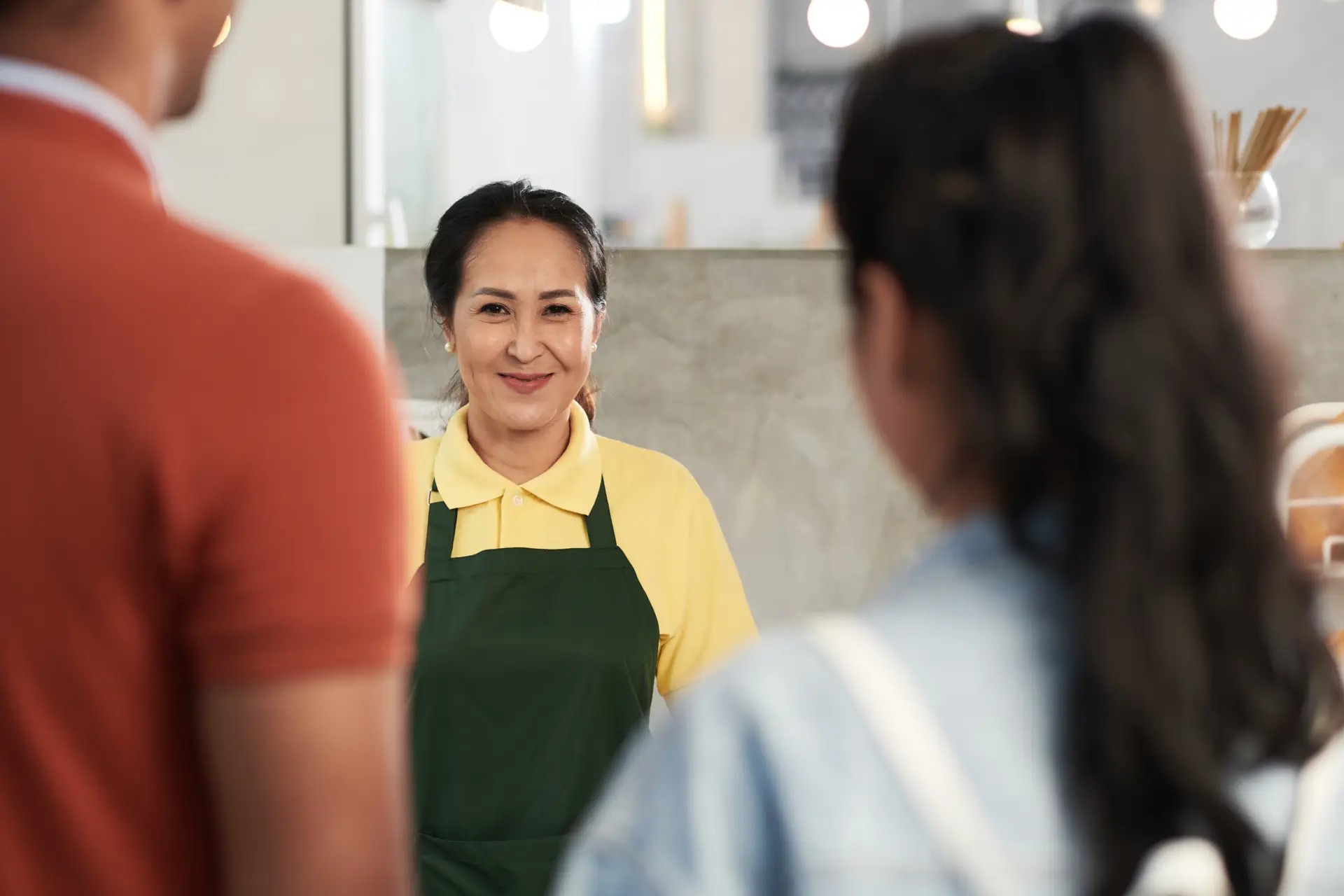 a woman in a green apron smiling